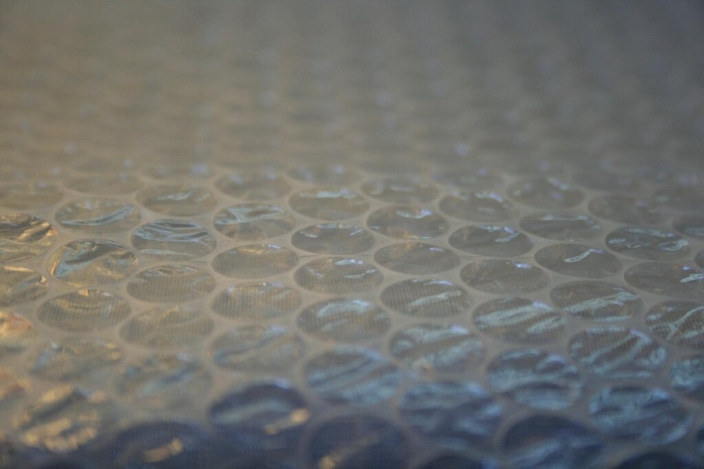 removing bubble wrap insulation sheet from window with water spray
