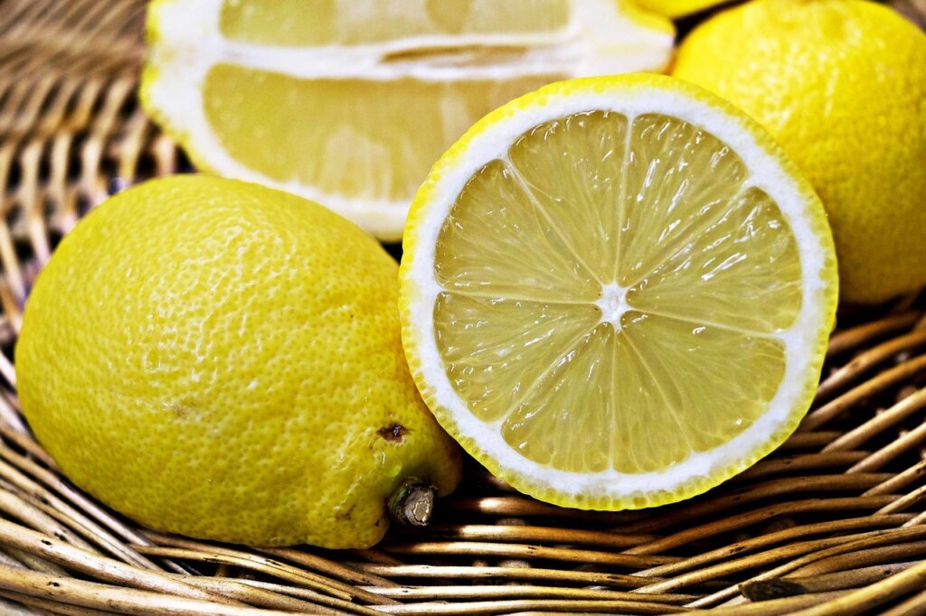 lemon cut in half next to a microwave-safe bowl with water