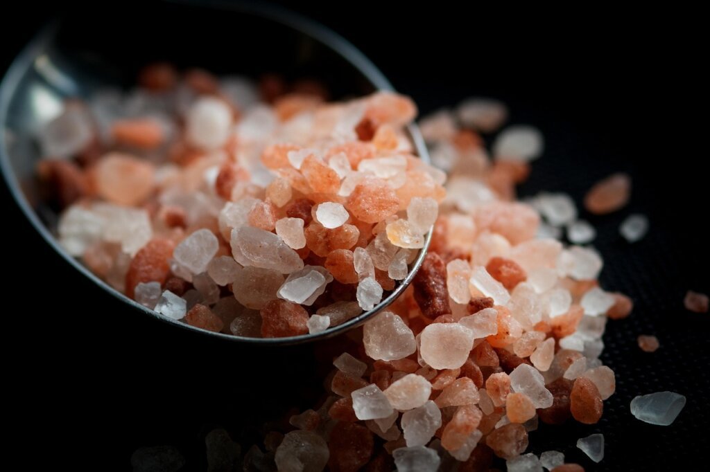 hand pinching salt over cooking pot