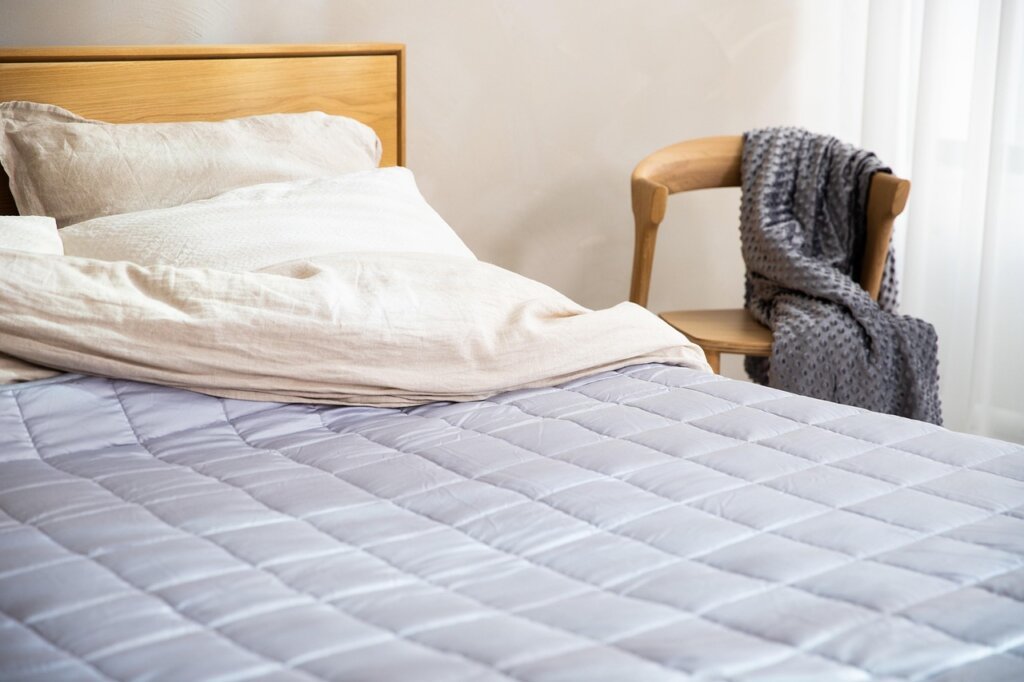 anti-dustmite mattress protector cover being fitted on bed