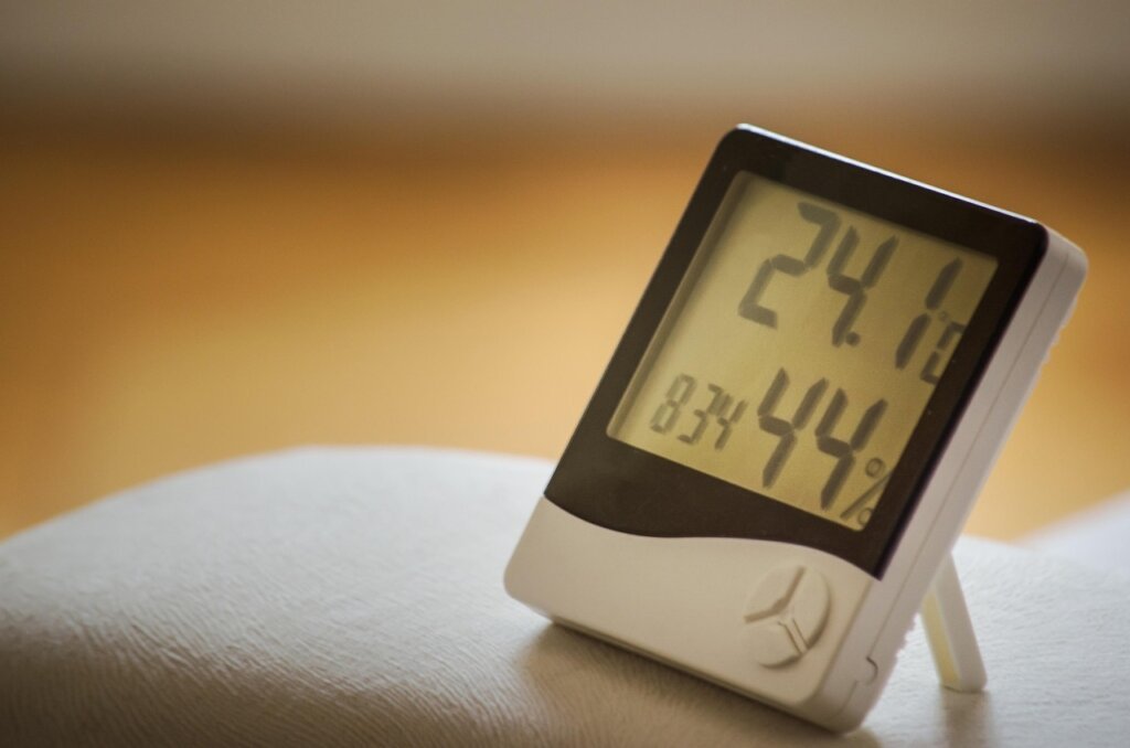 small digital hygrometer thermometer placed inside wooden cabinet