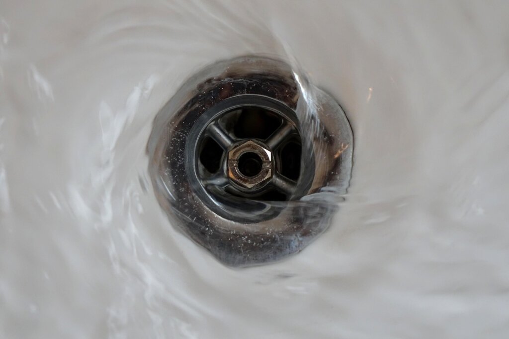 baking soda and vinegar being poured into sink drain
