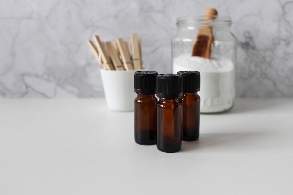 baking soda and white vinegar on wooden kitchen counter with laundry supplies