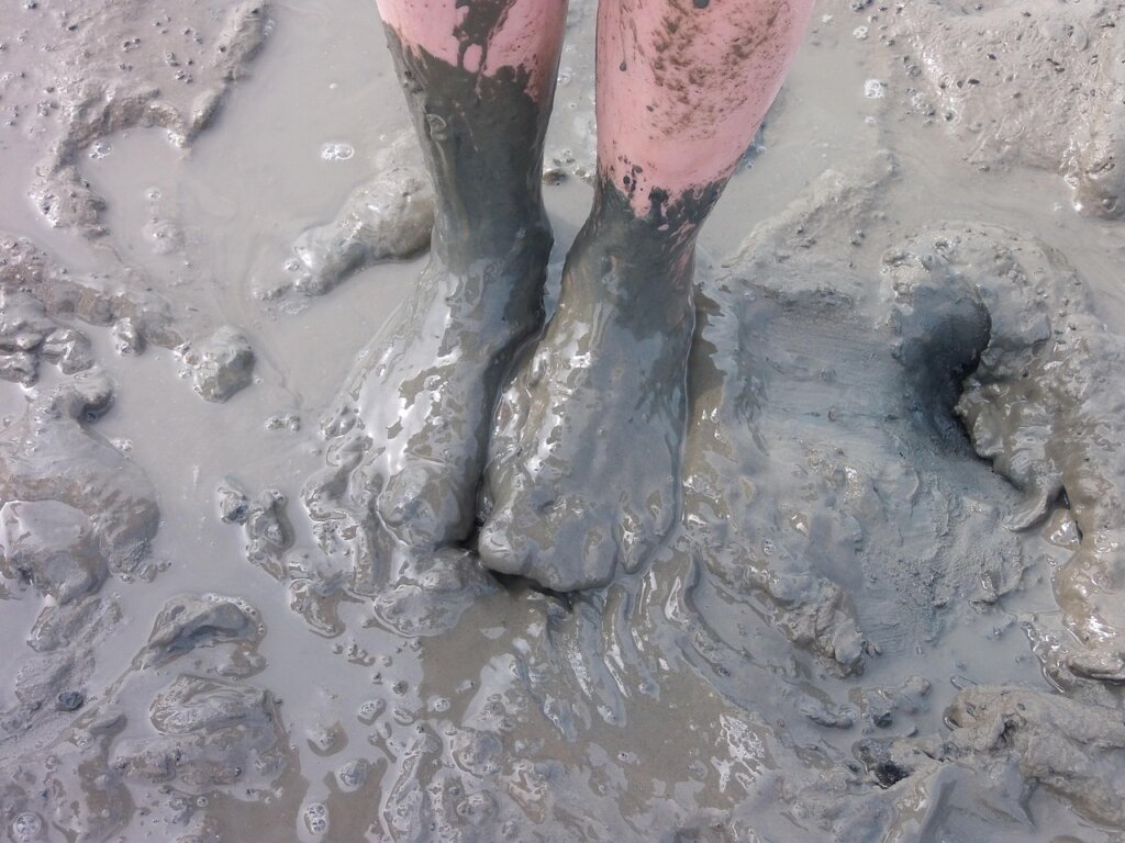 dirty entryway tile with mud and footprints