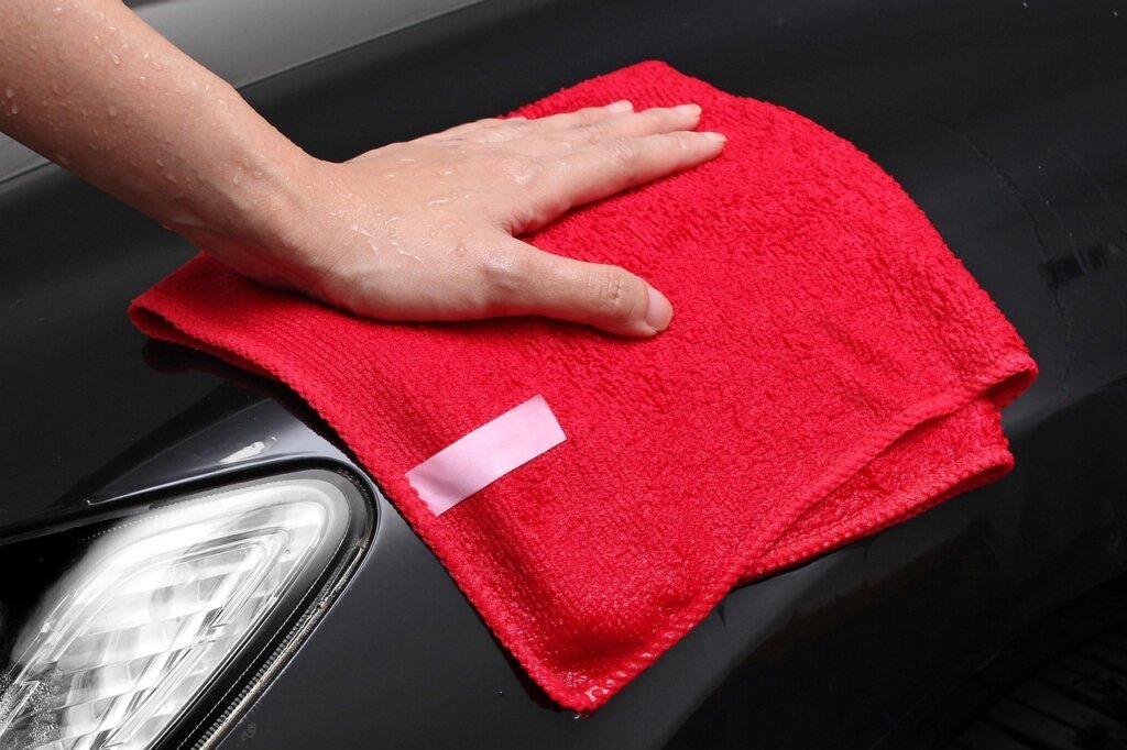 person wiping entryway tile with damp microfiber cloth