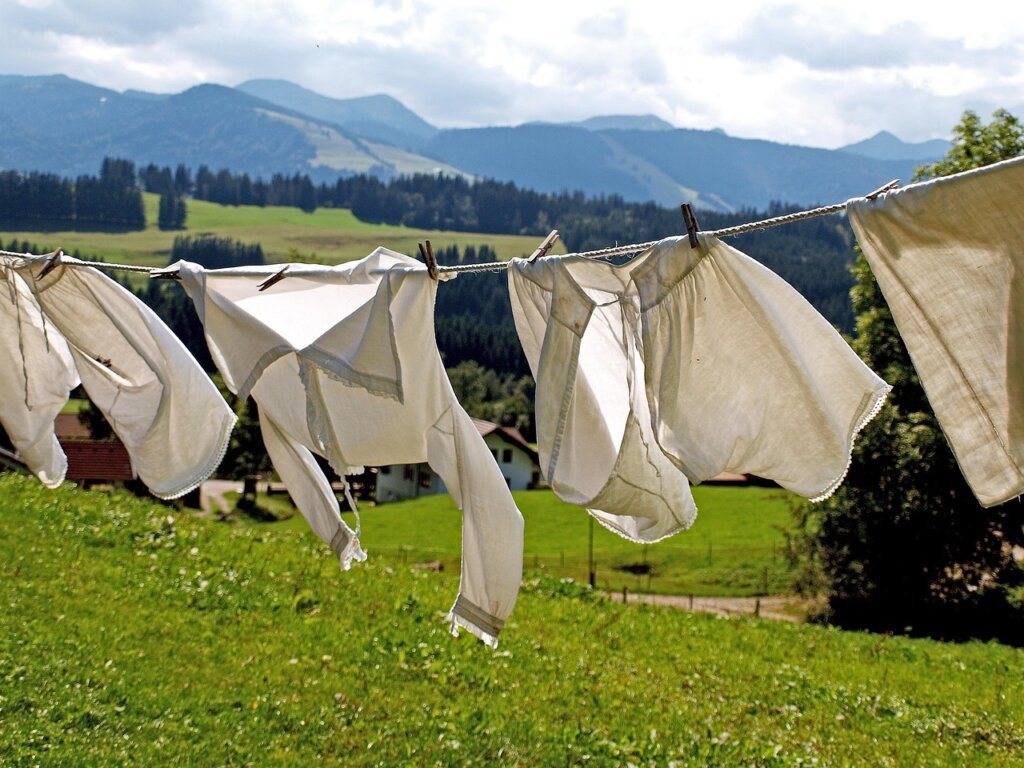 white shirts hanging in well-ventilated shaded area outdoors to dry