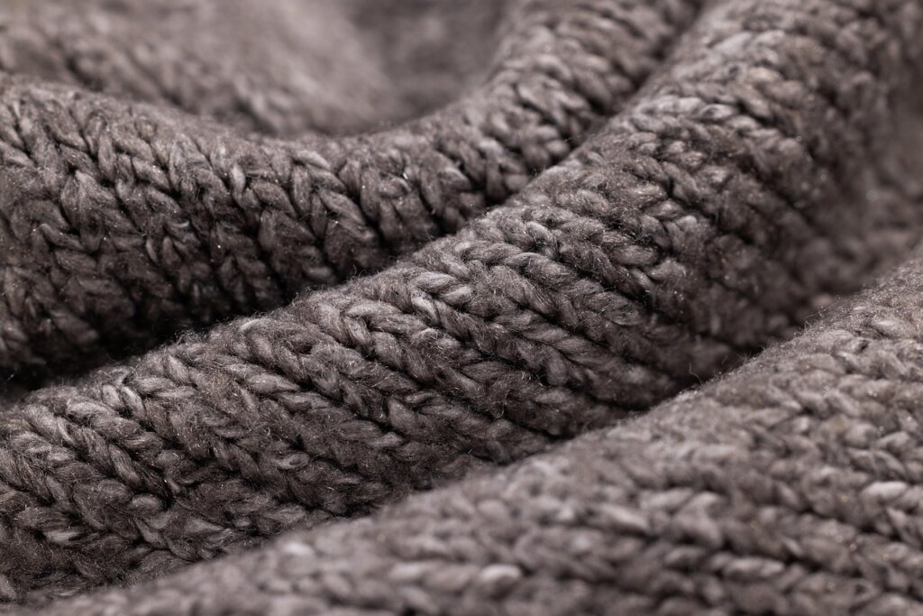 knit sweater with ink stain being gently dabbed with diluted dish soap on soft cloth