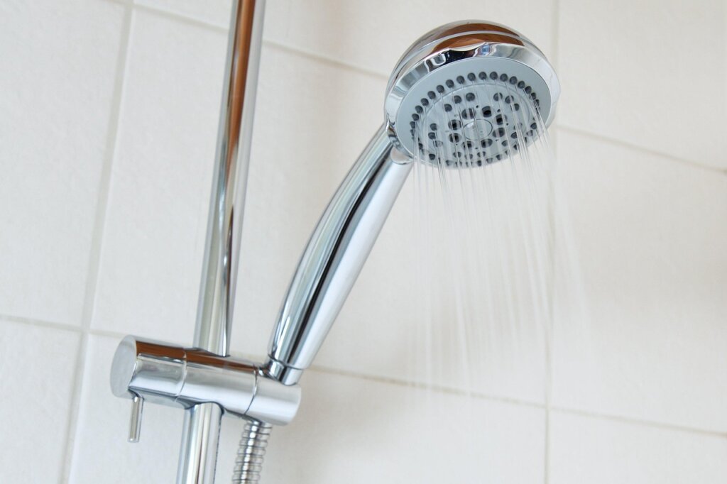 bathroom ventilation fan running after shower, clean white tiles