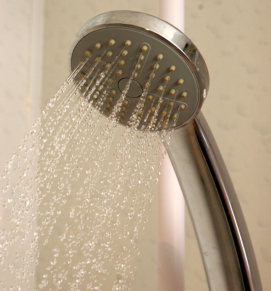 showerhead with white limescale buildup before cleaning
